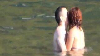 Horny couple having some fun in the water at the beach