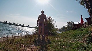 Naked by the lake and in front of the swimmer