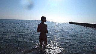 Nude model swims on a public beach in Russia