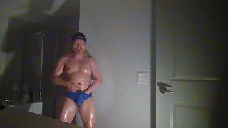 Oiled up and posing while wearing Speedos!