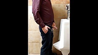 Ginger business man peeing at urinal