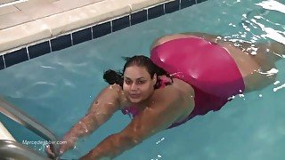 Amateur black bitch swimming in the pool and posing