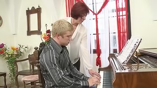 Older redhead piano teacher gives free lessons to her sexy student