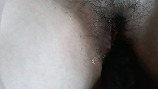 Fucks hairy cunt with black dildo