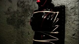 Latex bound slave gets tied up to a wall by her freaky mistress