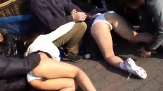 Two cute Asian babes getting used by a group of boys outside