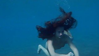 Julia is swimming underwater nude in the sea