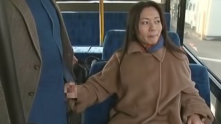 Fancy cougar dressed heavily giving a guy captivating handjob in the bus in reality shoot