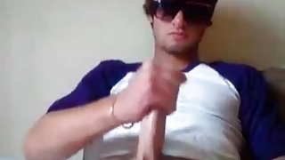 Sexy guy in sunglasses masturbates dick