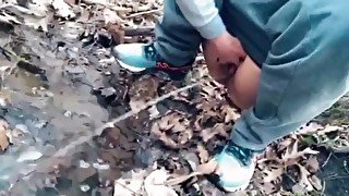 teen pissing in a forest stream after a run