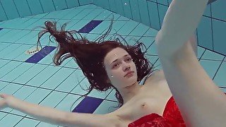 Red Dressed teen swimming with her eyes opened