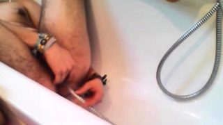 Bi-guy using shower head, squirting water, enema