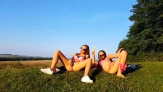 Naughty young lesbians masturbate together in the outdoors