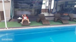 Girl with red hair sunbathes without panties by the pool