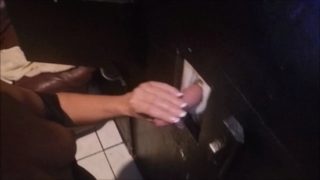Stroking cum out of cocks at a glory hole