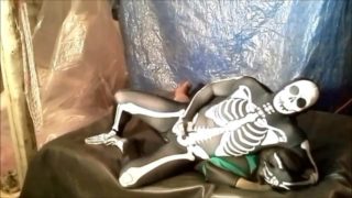 fantasy scene where spandex skeleton wrestles and humps frogman